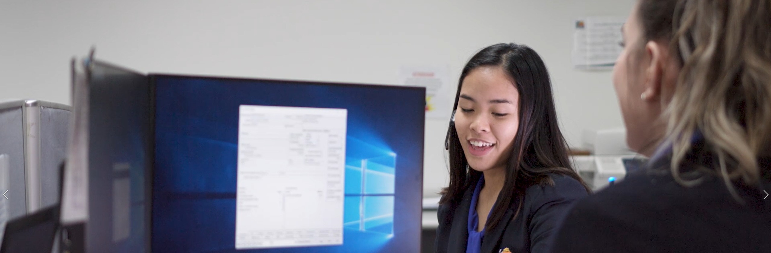 two people talking beside a computer