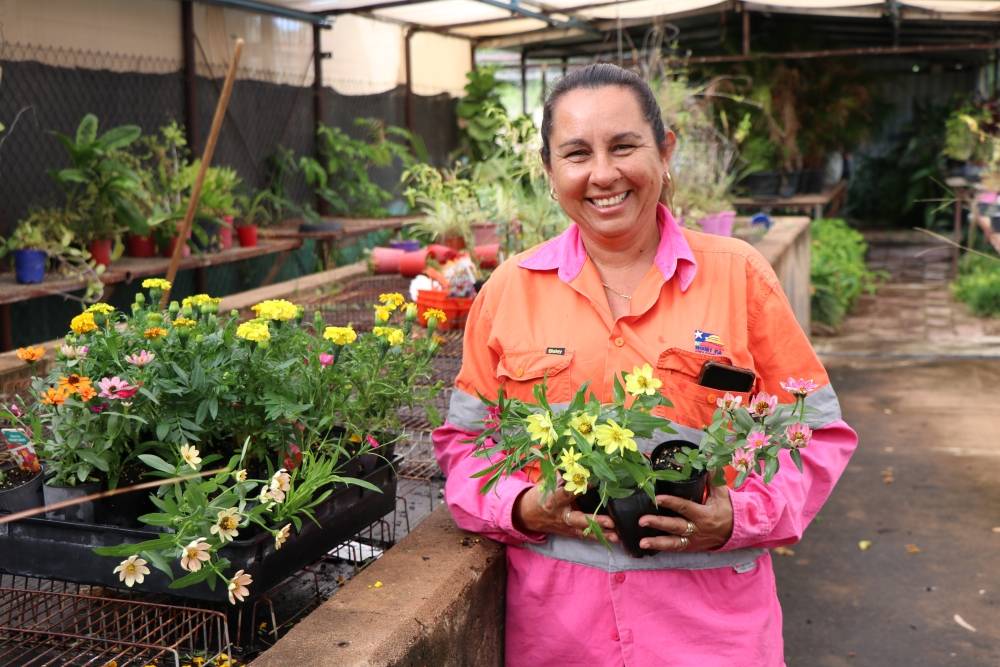 staff in greenhouse holding flowers